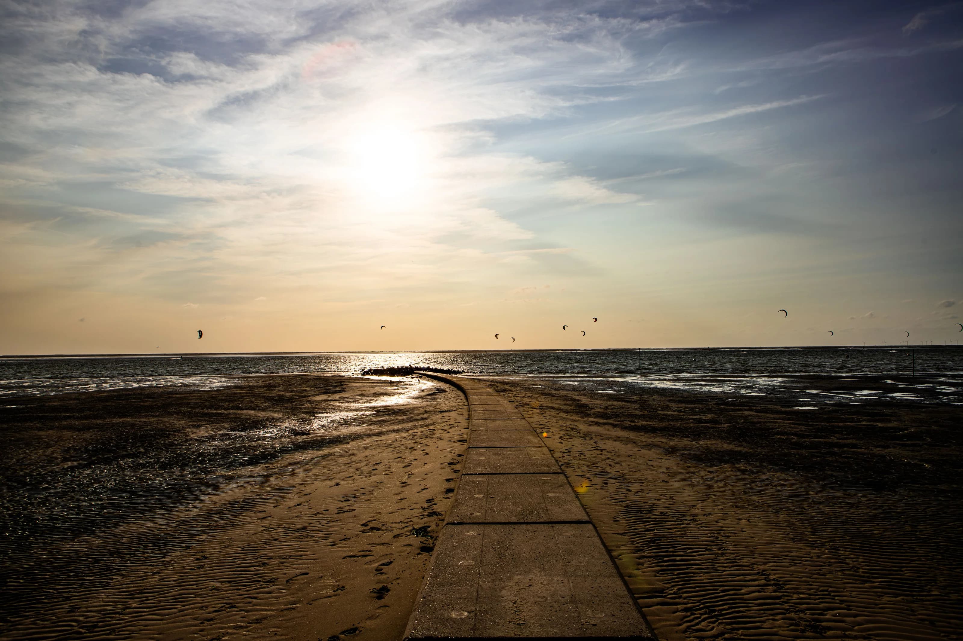 Sonne über der Nordsee und ein geschwungener Strandweg auf Borkum